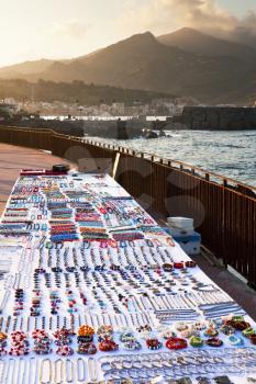 table with bijouterie on seafront at sunset, Sicily