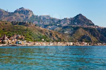 view on Taormina - very popular tourist  resort  on mountain and Gardini Naxos beach, Sicily