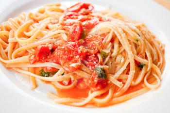 spaghetti with spicy tomato sauce on white plate closeup
