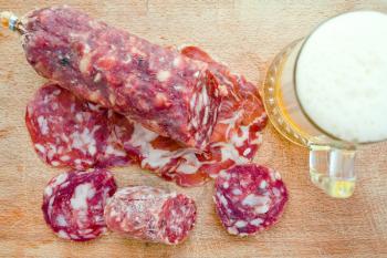 italian salami and glass of beer on wooden board