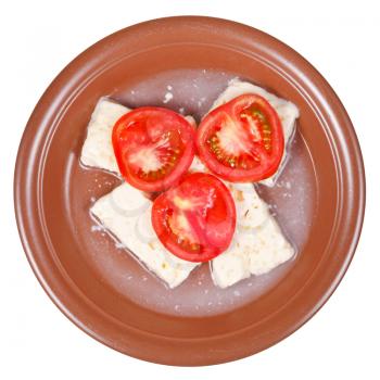 top view of sliced tomatoes and brined cheese on ceramic plate isolated on white background