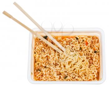eating of prepared instant noodles by wooden chopsticks from foam cap isolated on white background