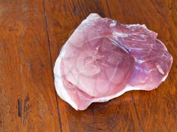 piece of raw pork neck on wooden table