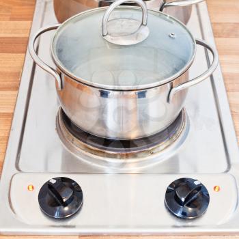 boiling water in metal pot on hotplate electric stove