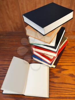 above view of blank open book on wooden table near bookcases