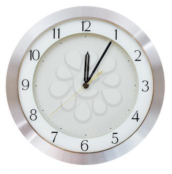 Five minutes after midnight (after twelve hours) on the dial round wall clock