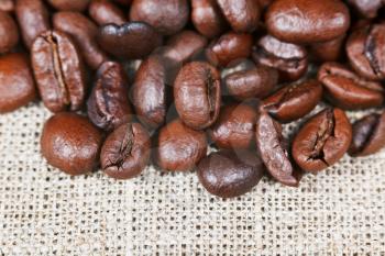 many roasted coffee beans on bagging close up
