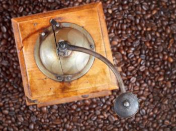 top view of retro manual coffee mill on many roasted coffee beans