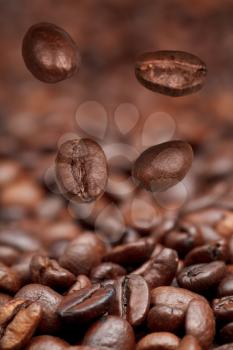 four falling beans and roasted coffee beans background with focus foreground