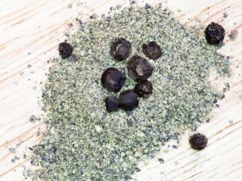 ground black pepper spice and peppercorns on wooden board