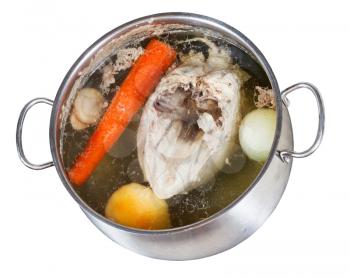 boiling of chicken broth with seasoning vegetables in steel pan isolated on white background