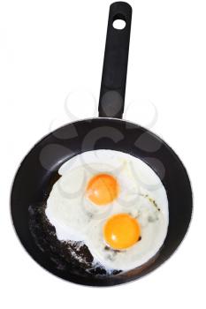 two fried eggs in frying pan isolated on white background