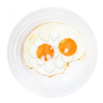 white plate with two fried eggs isolated on white background