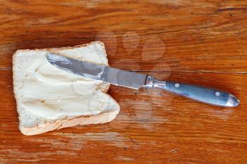 bread and butter sandwich with table knife on wooden table