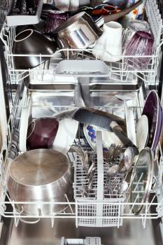 dirty cookware in open dishwasher close up