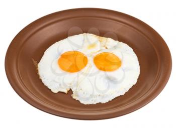 fried eggs on ceramic brown plate isolated on white background