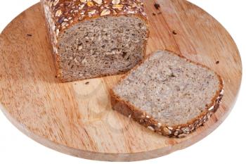 loaf of rye grain bread and sliced piece on wooden board on white background