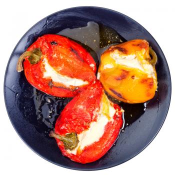 roasted peppers with goat cheese on black plate isolated on white background