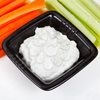 celery, carrot with Blue cheese dressing on white plate