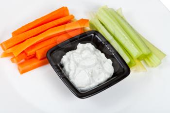 fresh celery, carrot with Blue cheese dressing on white plate