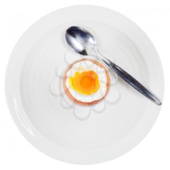 top view of soft boiled egg in egg cup and spoon on white plate isolated on white