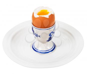soft boiled egg in egg cup on white plate isolated on white