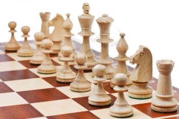 white chess figures placed on chess board close up