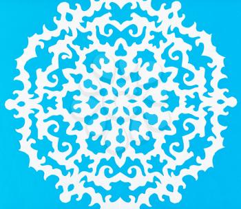 hand made cut out white snowflake on blue paper