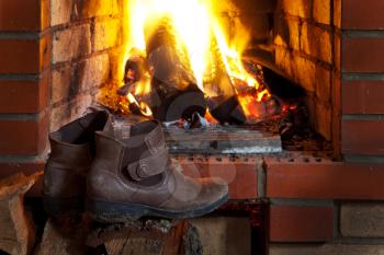 shoes dry near of fire in fireplace in evening time