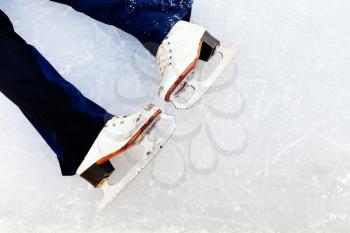 white leather skates on ice of outdoor open skating rink