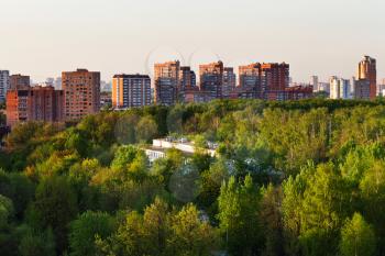 residential district and green urban park in summer evening