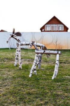 wooden horse figure on backyard of country village in spring evening