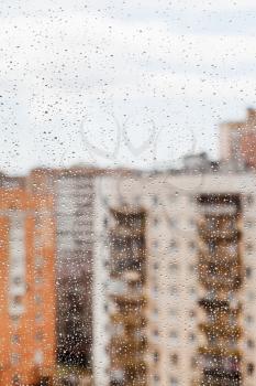 rain drops on glass window with town house background