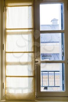 white textile drapes on sunny window in home