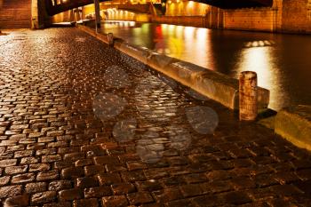 wet cobblestone pavement quay in Paris at night