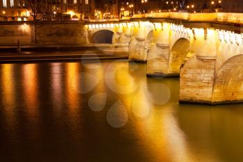 Pont Neuf through Seine river in Paris at night