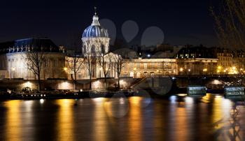view of French Academy above river in Paris at night