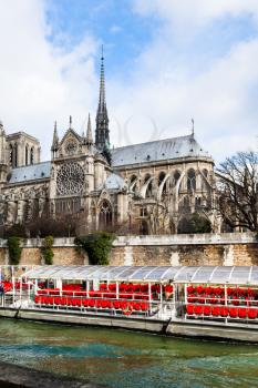cathedral Notre Dame de Paris and tourist boat in Seine River