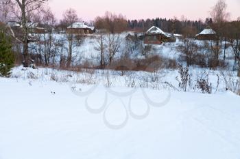view of snow country houses at pink winter dusk