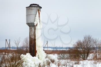 frozen tank tower in country field in winter day