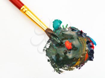 artistic paintbrush and blended multicolored watercolors paints with red gouache drop close up
