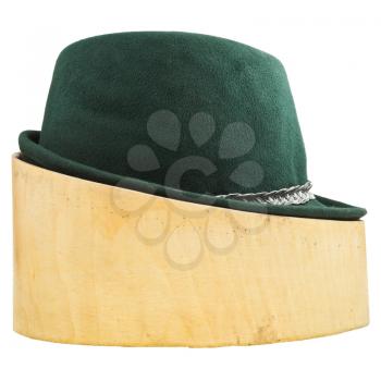 side view of green tyrolean felt hat on linden wood hat block isolated on white background