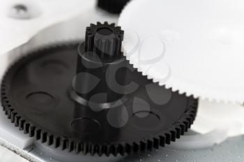 white and black plastic gears wheels close up