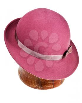 felt magenta hat with wide brim on wooden block isolated on white background