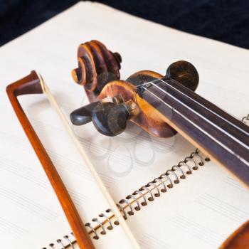 fiddle bow and scroll on music book close up