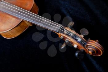 violin scroll on black velvet background close up