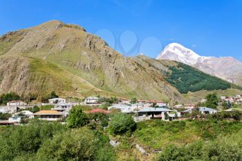 panorama with village Stepantsminda, Gergeti Trinity Church and Mount Kazbek in Caucasus Mountains in Georgia