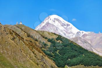 view of Gergeti Trinity Church and Mount Kazbek in Caucasus Mountains in Georgia