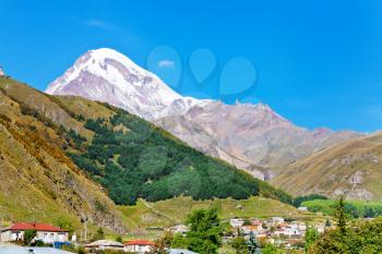Mount Kazbek over village Stepantsminda in Caucasus Mountains in Georgia