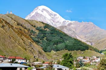 Mount Kazbek over village Kazbegi in Caucasus Mountains in Georgia